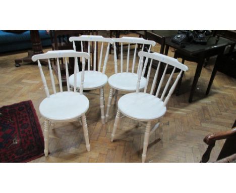 A set of four white painted Hereford type stick back country chairs with circular solid seats