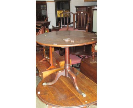 An oak tripod table with brass paw feet