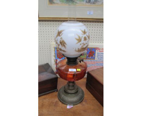 A late Victorian/Edwardian paraffin lamp, having a spherical opaque glass shade decorated with gilt birds in a landscape over