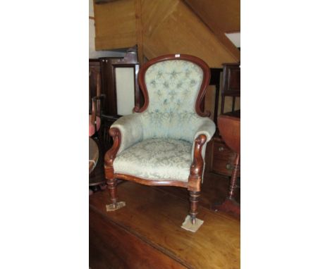 A Victorian mahogany show framed button back easy chair, scroll arms, raised on turned fore supports, leaf patterned upholste