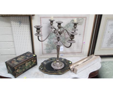 A silver plated four branch, five light, table candlestick, a papier mache dish of oval form, hand decorated with floral rese