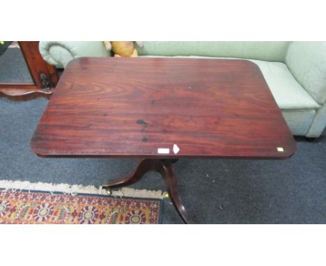 A George IV Cuban mahogany rectangular tripod table, raised on simple ring and gun barrel column and inverted sabre supports,