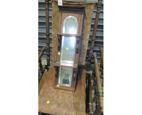 An Edwardian walnut narrow wall shelf with three tiers and mirror back