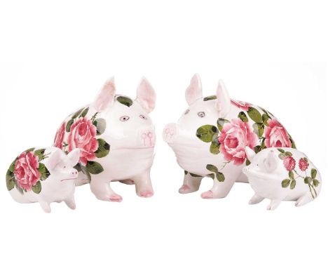 A pair of Wemyss pigs, with cabbage rose decoration, one signed 'Nekola Pinxt', 19 cm high x 28 cm wide, together with two sm