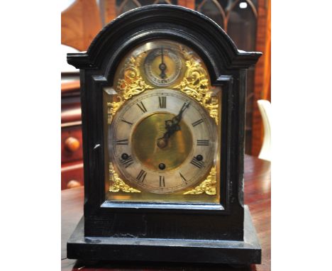 An early 20th century ebonised chiming mantel clock, gilded and silvered dial set with Roman numerals, height 37cm.