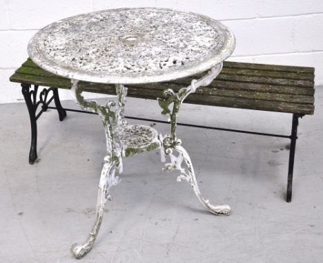 A 20th century weathered garden bench, width 123cm and a white painted weather worn metal garden table with scrolling decorat