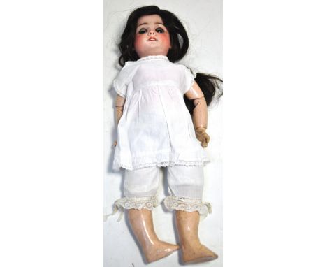 A late 19th early 20th century French bisque head doll with porcelain teeth, composite body with some original clothing to in