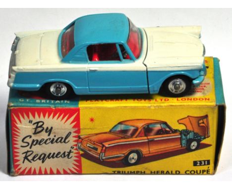 A Corgi Triumph Herald coupe in blue and white finish with red interior, spun wheels and black tyres, no.231 boxed. CONDITION