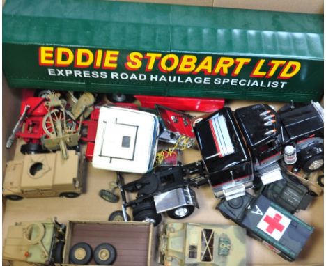 A group of assembled plastic construction kits of WWII vehicles and two large scale models of an American truck and an "Eddie