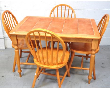 A retro pine tile topped dining table on ring turned legs, width 115cm and three pine Ercol style stick back chairs (4).