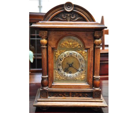A late 19th century walnut dome top mantel clock, gilded dial set with Arabic numerals, height 42cm.