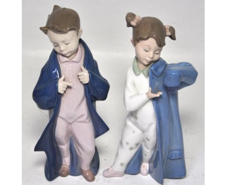 A large Nao figurine of a girl getting into her pyjamas and a Nao figurine of a boy in his dressing gown (2).