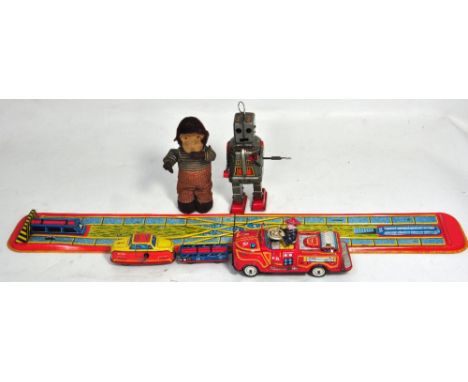 A mechanical monkey, a tinplate fire engine, a tinplate train and wagon with a small track and signal and a tinplate robot (4