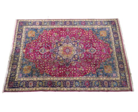 Tabriz woollen carpet, late 20th Century, cerise pink field centred with an ochre, fawn and blue foliate reserve, the field d