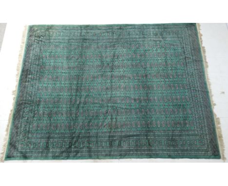 Turkman bokhara woollen carpet, all over jade green field with eight rows of guls within a multi-guardstripe border, size app