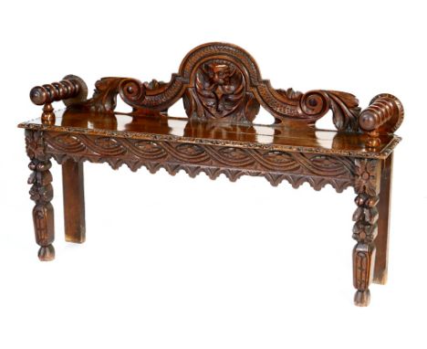 Victorian carved oak hall bench, circa 1880, the back piece carved with scrolls and centred with a mask, bobbin turned arms, 