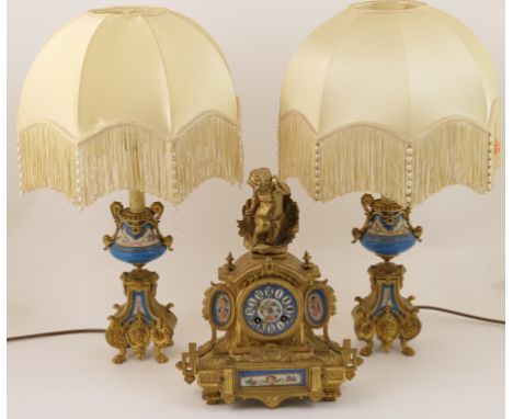 French gilt spelter mantel clock garniture, circa 1875, the clock surmounted with a cherub emerging from a shell, over a Sevr