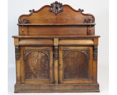 Victorian mahogany chiffonier, circa 1860, the shaped back with a single shelf raised on short turned columns, over a base fi