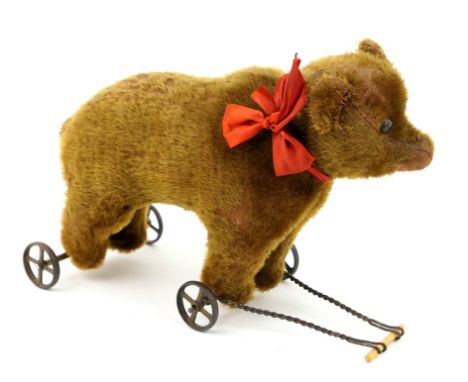 Steiff pull-along plush bear, circa 1900-10, with boot black eyes, brown fur, cast four spoke wheels (rear axle replaced), he