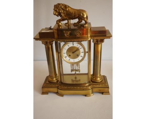 Vincenti & Cie Ornate brass mantle clock with lion finial, Corinthian column, and detailed base. Made in France, from the 19t