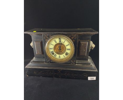 Metal mantle clock with enamel face, flanked with brass lion head, W38cm h25cm. 