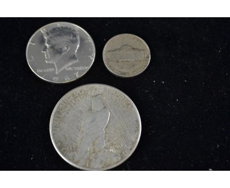 One U.S 1926 Peace silver dollar, one U.S 1967 half dollar, and one U.S 1942 five cents 