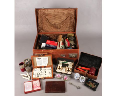 A case of collectables. Including travelling cutlery set, dominoes, unframed sampler, paperweights, tins, etc.  