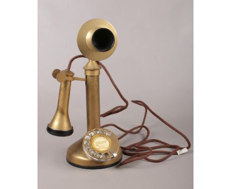 A stick brass telephone. Comprising of a ring dial to the circular base and etched to the front G E C, wired ready to plug in