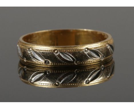 An 18ct yellow and white gold wedding band. Size R 1/2. 4.47g.  