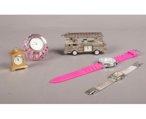 A group of clocks/wristwatches. Caithness glass/clock paperweight, fire engine model quartz clock etc  