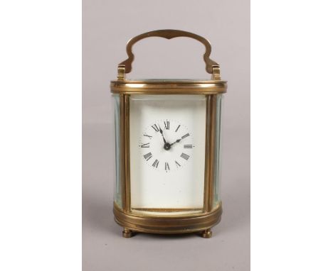 A miniature oval carriage clock with key. (10.5cm height 6.5cm width)  There are no cracks or chips in the glass, and the lot