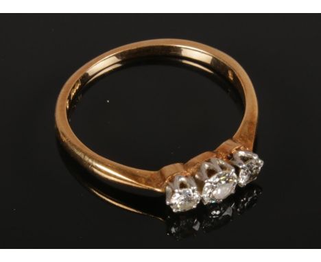 An 18ct Gold and Platinum Three Stone Diamond Ring. Largest Stone Size = 1/8ct.  Ring Size = M 1/2. Total Weight: 2.10g  