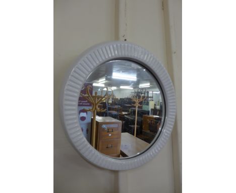 A mid 20th Century white ceramic framed circular mirror 