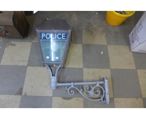 A Police street lantern, on wrought metal wall hanging bracket 