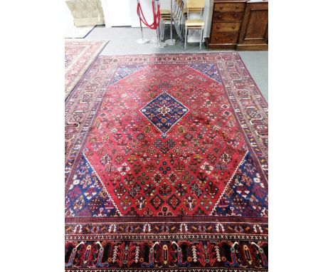 A North-west Persian carpet, central lozenge medallion, on a patterned red field, border within multi-guards, 420cm x 305cm.