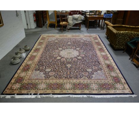 Tabriz pattern carpet, central medallion on a patterned deep blue field, border within guards, 405 x 305cm.