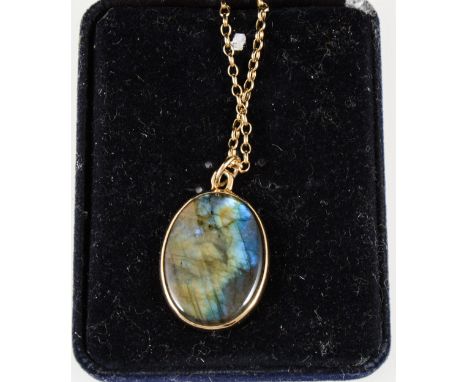 A labradorite pendant and chain, the oval cabochon cut labradorite 37mm x 20mm, set in a plain yellow metal frame on a 9 cara