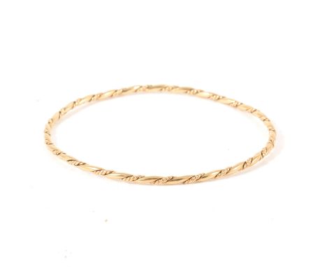 A 9 carat yellow gold 2.3mm wide slave bangle, twisted design, internal diameter 65mm, hallmarked London 1976, approximate we