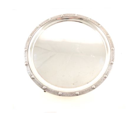 A silver salver, circular with raised Celtic design border, three dolphin feet, London 1934, 35.5cm diameter, weight approx. 