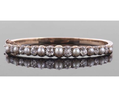 A 'pearl' and diamond bangle, the alternating 'pearls' in closed backs, with claw mounted old mine cut and one round brillian
