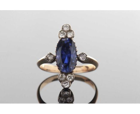 A sapphire and diamond ring, the oval mixed cut sapphire, approx. 12 x 7.5 x 5.7mm, claw mounted with a trefoil of round diam