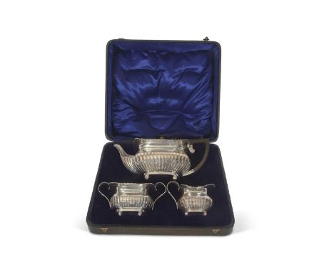 George V silver three piece tea set comprising teapot, cream jug and twin handle sugar bowl of squat oval form, applied gadro