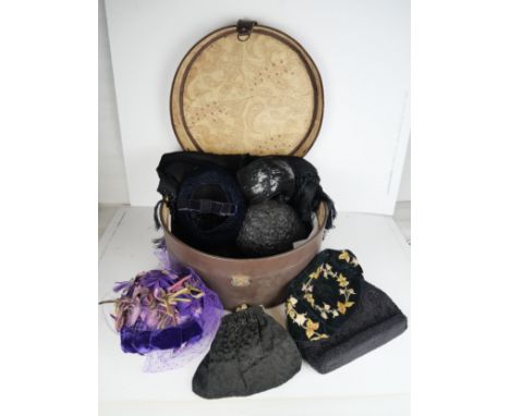 A hat box containing assorted hats, evening bags and a shawl