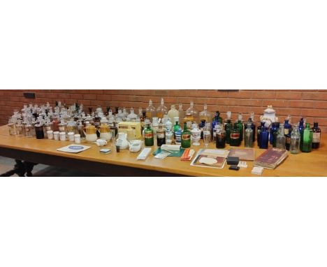 An extensive collection of early 20th Century pharmaceutical jars and vials, together with pill making and suppository moulds