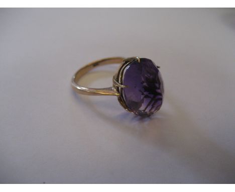 A yellow metal purple stone ring.