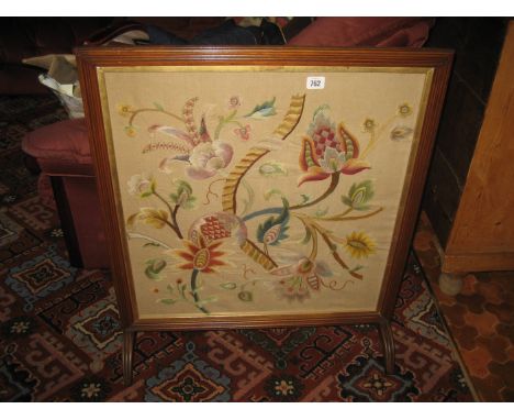 A mahogany framed floral tapestry screen.