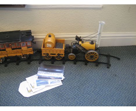 A Hornby 'Stephensons Rocket' live steam engine with two carriages and track etc.