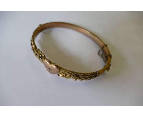A 9ct gold bangle with embossed floral decoration (8.4g). 