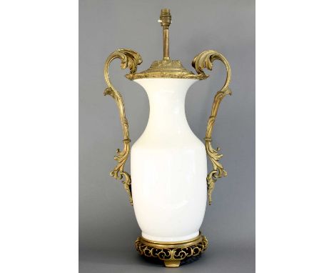 A Gilt Metal Mounted White Porcelain Lamp, late 19th/early 20th century, of baluster form with leaf-sheathed handles and scro