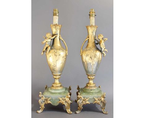 A Pair of French Gilt Metal and Onyx Lamp Bases, of baluster form applied with putti, on scroll cast square bases, 47cm highS